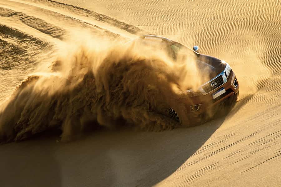Doha Desert Safari: Sandboarding, Camel Ride & Swimming Fun - Dune bashing across the golden sand