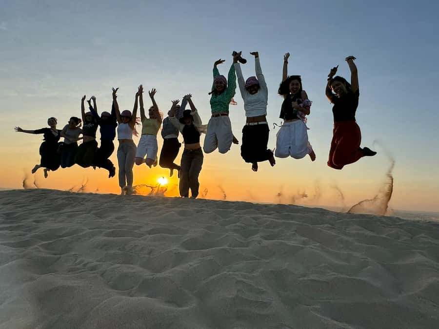 Doha: Sunset Safari, Dune Bashing, Sandboarding & Camel Ride - Meeting camels at the local camp